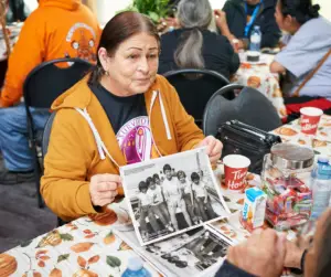 Survivors' Secretariat Board Member and Survivor Diane Hill reviews historical photographs of children who attended the Mohawk Institute Indian Residential School, supporting ongoing truth-telling and research efforts.